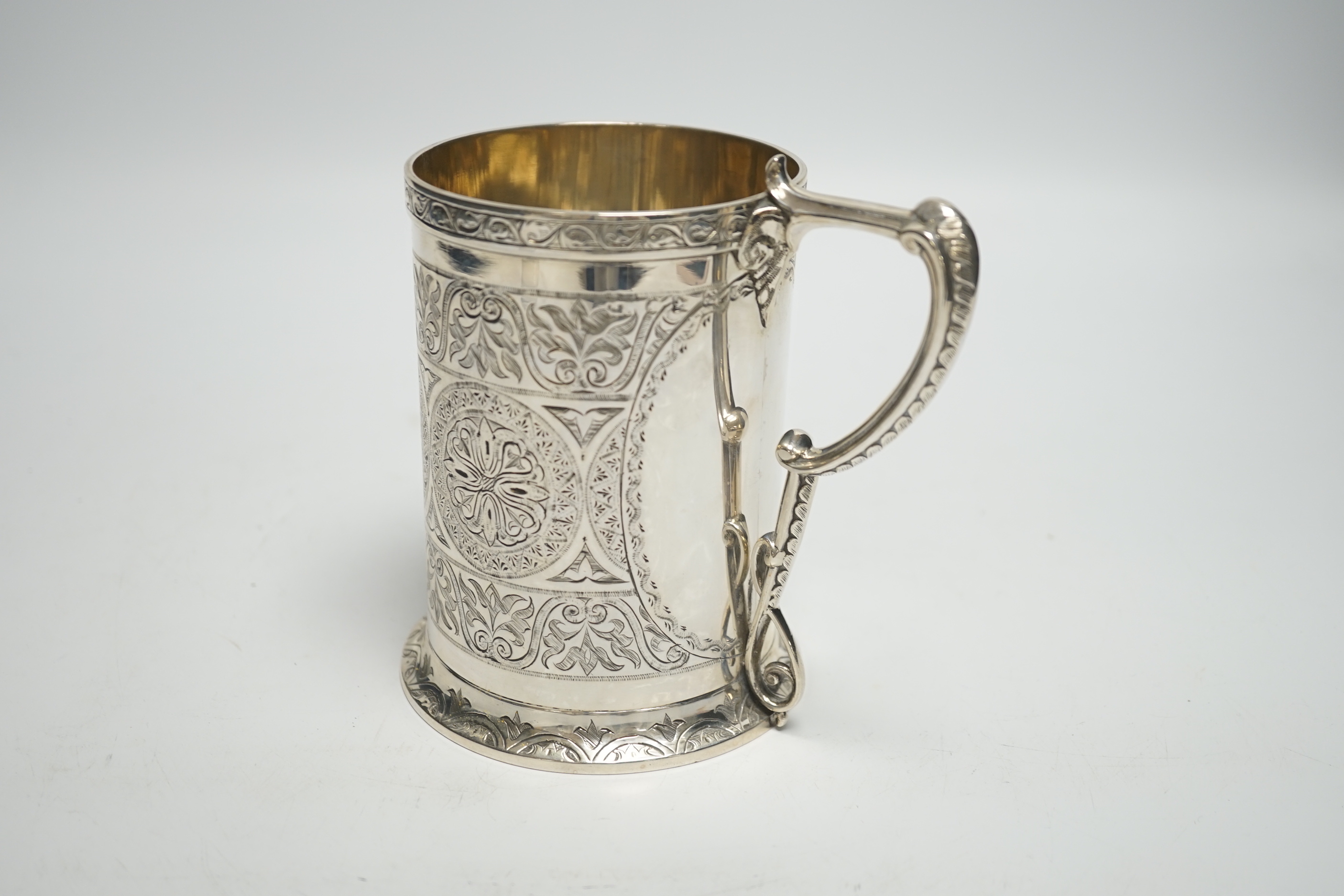 A Victorian engraved silver mug, with ornate handle, George Unite, Birmingham, 1869, height 12.4cm, 12.4oz.